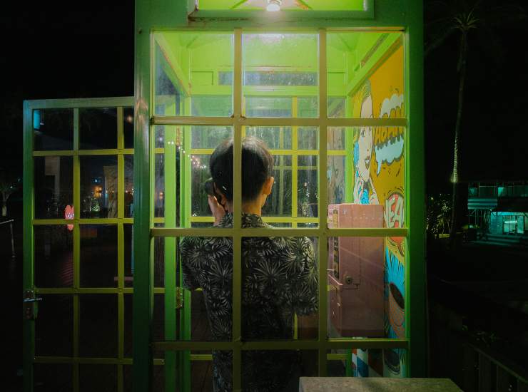 persona di spalle dentro cabina telefonica